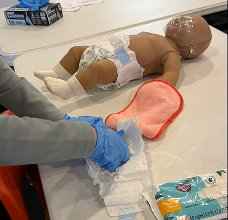 Close-up of a student practicing infant care skills during hands-on training